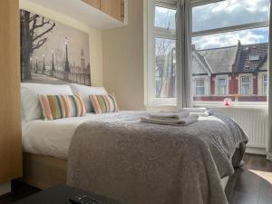 ein Schlafzimmer mit einem Bett und einem großen Fenster in der Unterkunft Amazing Studio Room in Walthamstoww in London