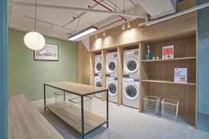 a laundry room with three washing machines and a table at M Village Cửu Long in Ho Chi Minh City