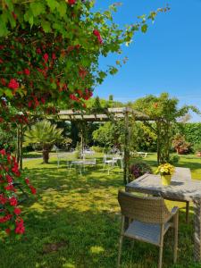 un tavolo e sedie in un giardino fiorito di Casa Pianta a Cavallino-Treporti