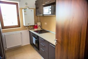 a small kitchen with a stove and a microwave at Apartament Mamaia Nord in Mamaia Nord