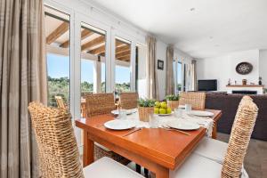 a dining room with a wooden table and chairs at Villa Sa Gavina - Addaia in Port d'Addaia