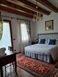 una camera con letto, tavolo e lampadario a braccio di Casa Pianta a Cavallino-Treporti