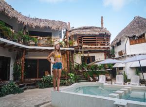 Arte Sano Hotel - Adults only في جزيرة هول بوكس: امرأة تقف على حافة قرب حمام السباحة