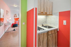 a kitchen with red and green walls and a sink at Hotel Am Gottesauer Schloss in Karlsruhe