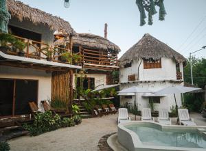 uma casa com piscina, cadeiras e guarda-sol em Arte Sano Hotel - Adults only em Ilha Holbox