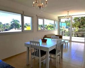 comedor con mesa blanca y sillas en Azares departamentos en alquiler temporario en Valeria del Mar