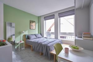 a bedroom with a bed in a room with green walls at M Village Living Cửu Long in Ho Chi Minh City