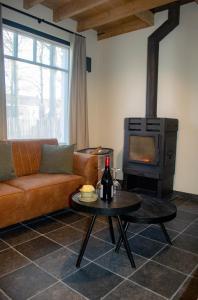 ein Wohnzimmer mit einem Sofa und einem Holzofen in der Unterkunft Kerkdreef8 in Merkem