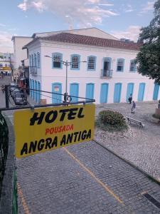 una señal de hotel frente a un edificio blanco en Hotel Pousada AngraAntiga, en Angra dos Reis