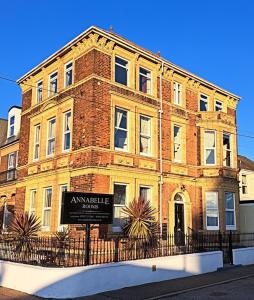 a large brick building with a sign in front of it at Annabelle Rooms in Great Yarmouth