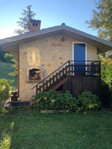 ein kleines Steinhaus mit einer Veranda und einer Tür in der Unterkunft Borretta in Serramazzoni