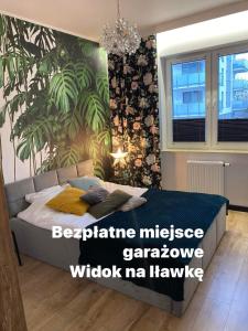1 dormitorio con 1 cama y una planta grande en Apartament Tomek, en Iława