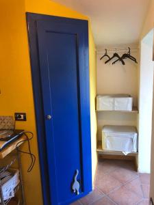 eine blaue Tür in einem Zimmer mit einem Schrank in der Unterkunft Borretta in Serramazzoni