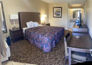 a hotel room with a bed and a desk at Hilltop Inn Pittsburgh in Pittsburgh