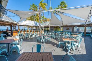 a restaurant with tables and chairs with the ocean in the background at 209 Little Harbor Inn in Ruskin