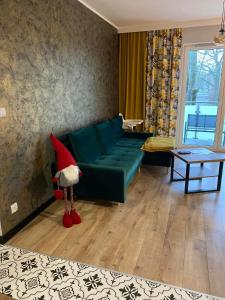 una sala de estar con un sofá verde con sombrero de Santa en Apartament Tomek, en Iława