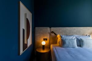 een slaapkamer met een bed met een blauwe muur bij Regras 45 Building A by LovelyStay in Porto