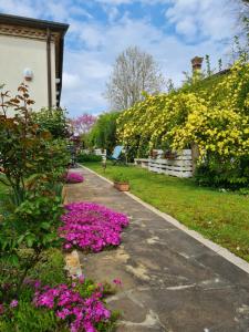 a garden with pink flowers on a sidewalk at Casa Pianta in Cavallino-Treporti