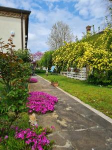 a garden with pink flowers on a sidewalk at Casa Pianta in Cavallino-Treporti