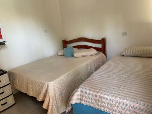 duas camas num pequeno quarto com duas camas em Cantinho da mery 1 em Maragogi