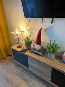 a santa claus sitting on a table with two plants at Apartament Tomek in Iława