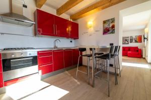 a kitchen with red cabinets and a counter top at Chalet la Cà del Fermo in Perledo +13 photos