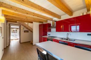a kitchen with red cabinets and a white counter top at Chalet la Cà del Fermo in Perledo