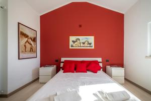 a bedroom with red walls and a bed with red pillows at Chalet la Cà del Fermo in Perledo