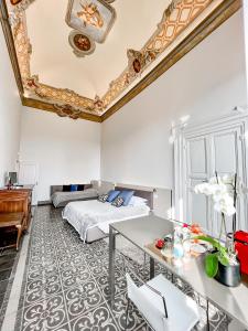 een slaapkamer met een bed, een tafel en een bureau bij B&B Palazzo Bruchi in Siena
