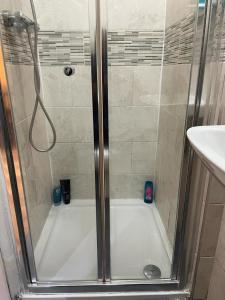 um chuveiro com uma porta de vidro na casa de banho em Amazing Studio Apartment in North East London em Londres