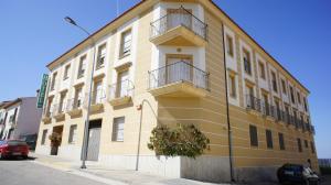 a yellow building with two balconies on a street at Hotel Apartamentos Kantara Al-Saif in Alcántara