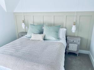 um quarto com uma cama com almofadas azuis e brancas em Luxury Modern Cotswold Cottage em Stow on the Wold