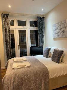 a bedroom with a bed with two towels on it at Amazing Studio Apartment in North East London in London