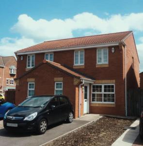 a black car parked in front of a brick house at Perfectly placed 3 bed home in a peaceful close in Darlington