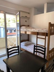 a dining room with a table and two bunk beds at Aleksi rooms in Shëngjin