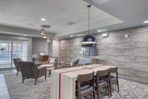 a lobby with a table and chairs in a room at Candlewood Suites Milwaukee Airport - Oak Creek, an IHG Hotel in Greendale