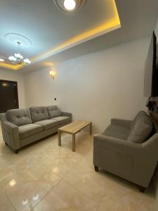 ein Wohnzimmer mit 2 Sofas und einem Couchtisch in der Unterkunft قمم بارك Qimam Park Hotel 4 in Abha