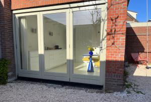 a large sliding glass door with a vase in it at Aventure in Noordwijk