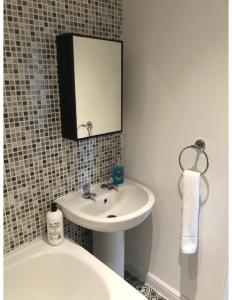 a bathroom with a sink and a mirror and a toilet at Perfectly placed 3 bed home in a peaceful close in Darlington