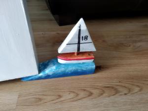 a toy boat with a sail on the water at Fishermans Cottage in Killough