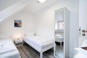 a bedroom with two beds and a mirror at Albatros OG in Tinnum