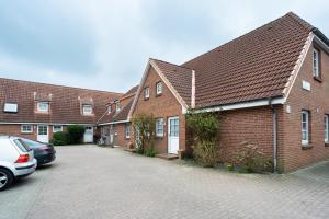 a row of brick houses with cars parked in a driveway at Albatros OG in Tinnum