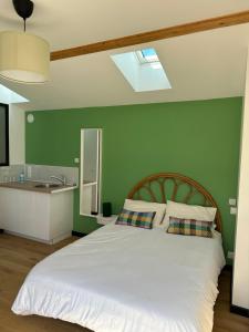 - une chambre avec un lit blanc et un mur vert dans l'établissement GREEN&PURPLE STUDIO 24-24 Access, à Bois-Colombes