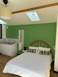 sypialnia z białym łóżkiem i zieloną ścianą w obiekcie GREEN&PURPLE STUDIO 24-24 Access w mieście Bois-Colombes