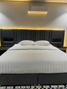 ein großes weißes Bett mit zwei Kissen darauf in der Unterkunft قمم بارك Qimam Park Hotel 4 in Abha