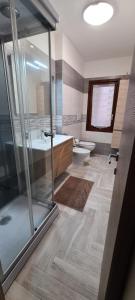Un baño con ducha, lavabo e inodoro. en Casa Laura, Quartu Sant'Elena, en Su Forti