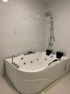 eine weiße Badewanne im weißen Badezimmer in der Unterkunft قمم بارك Qimam Park Hotel 4 in Abha