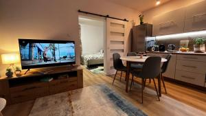 Comfortable apartment for 1-4 guests في شورزوف: غرفة معيشة مع تلفزيون وطاولة مع كراسي