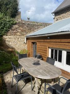 une table et des chaises en bois sur une terrasse dans l'établissement La maison du pêcheur, à Saint-Quay-Portrieux