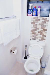 a white bathroom with a toilet and a towel at Serene AirBNB Lower Kabete-Near Ksg in Nairobi